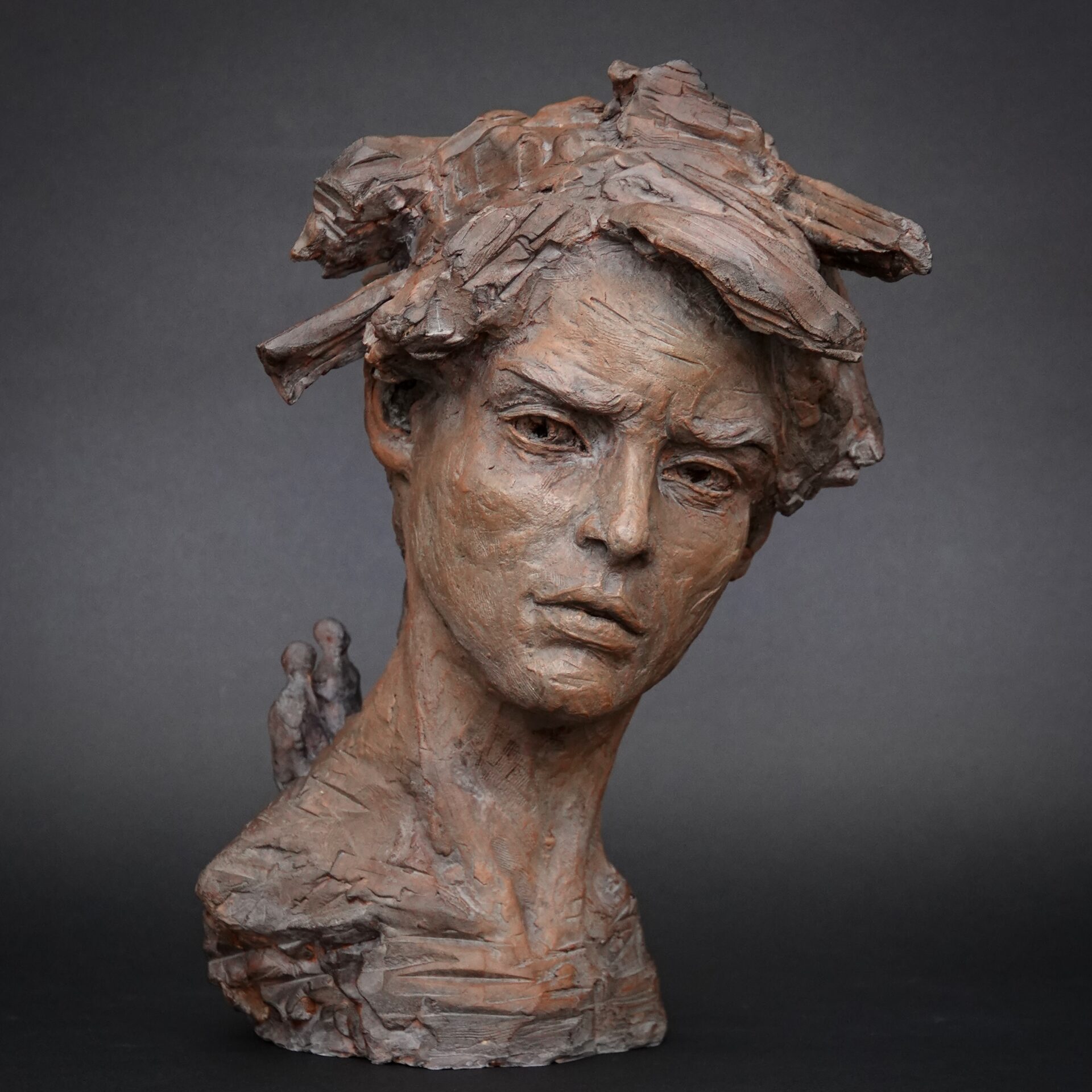 Sculpture, portrait d'un homme avec des personnages sur son dos