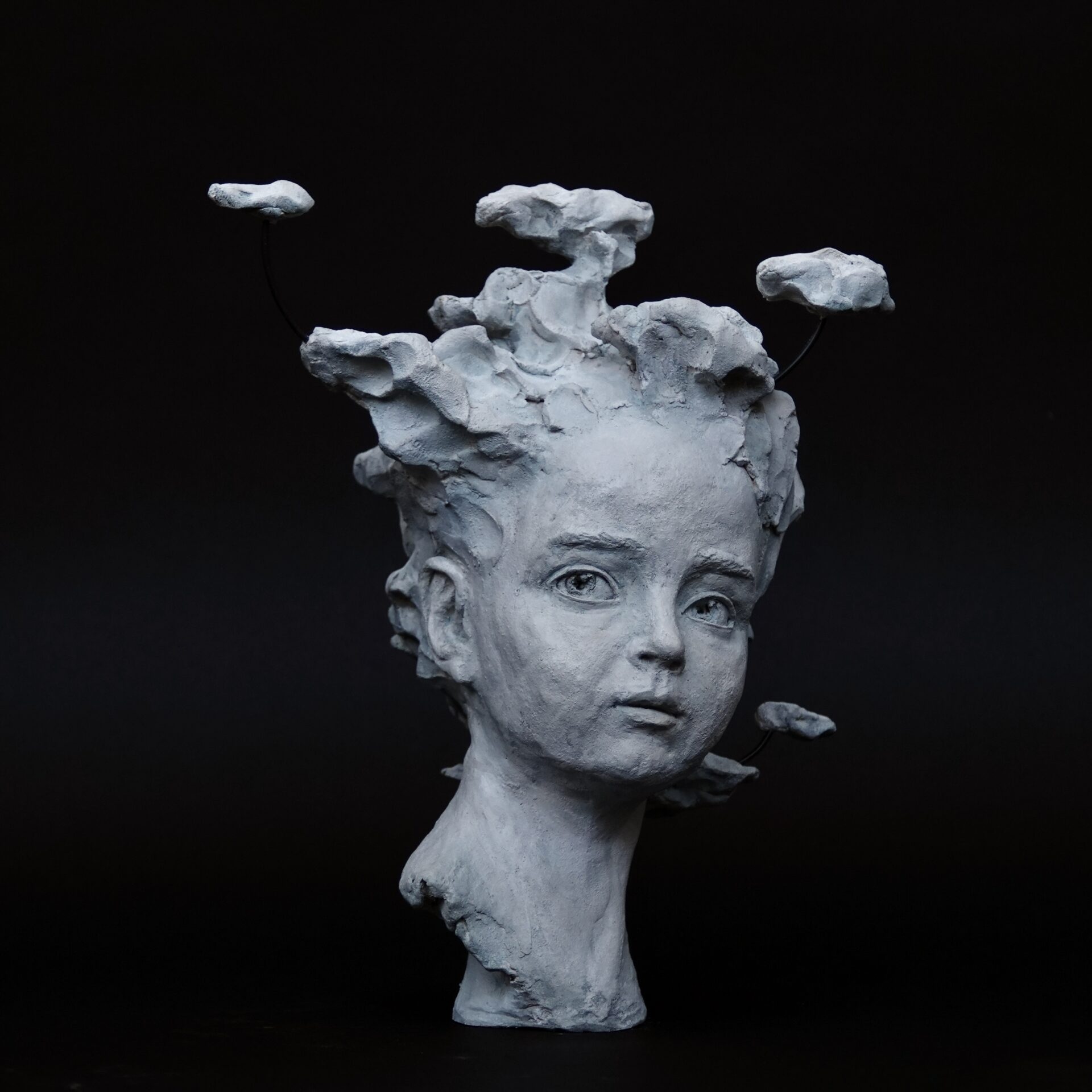Sculpture, portrait d'enfant avec des nuages